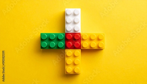 Colorful LEGO plus sign on yellow background
