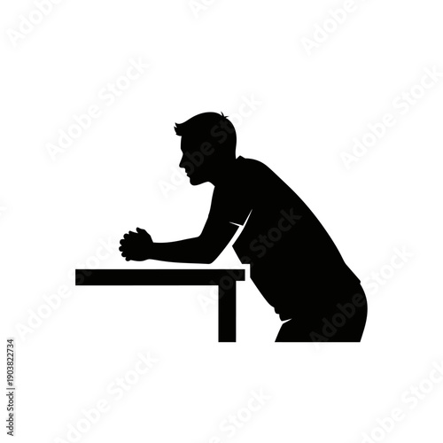 Silhouette of a man praying at a table in a reverent pose