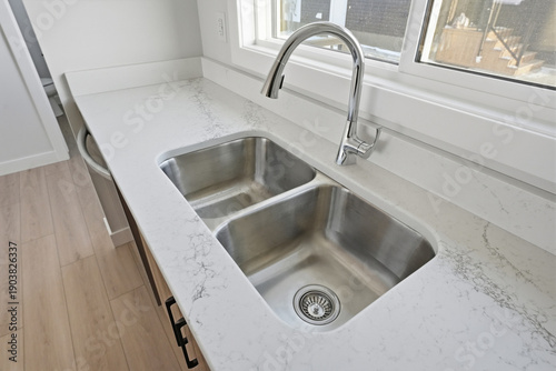 Принти на полотні Stainless steel sink with a silver faucet sits on a white marble countertop