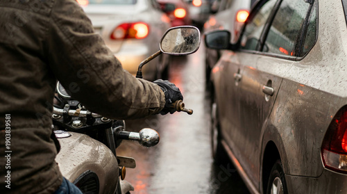 Man riding motorcycle in rainy weather traffic. Urban commuter navigating congested city streets during a downpour. Transportation and modern lifestyle.