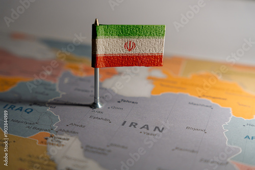 Iran flag pinned on political map over Iran in Middle East region. . Public domain World political map background. Source: CIA World Factbook (Public Domain).