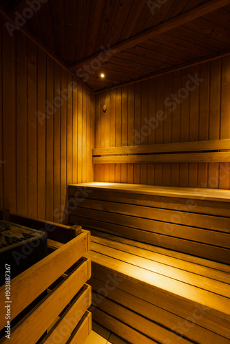 Empty wooden sauna interior with benches and warm lighting