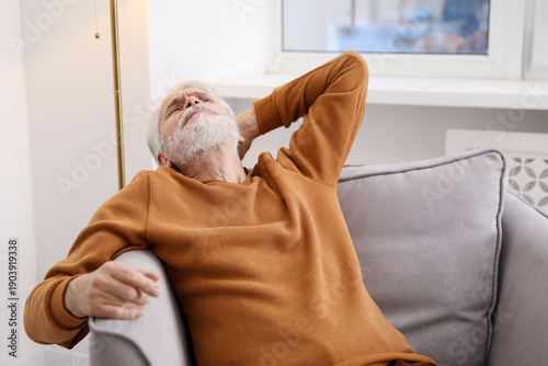 Canvas Print Unhappy senior man feeling fatigue on sofa at home