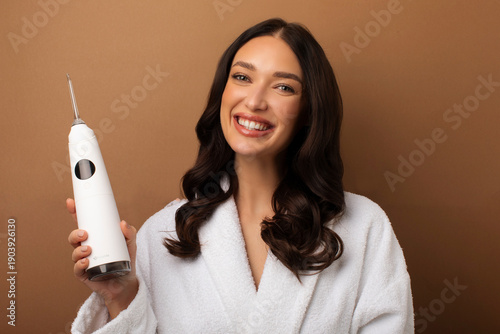 фотографія Happy lady using dental irrigator for oral hygiene, focusing on modern dental ca