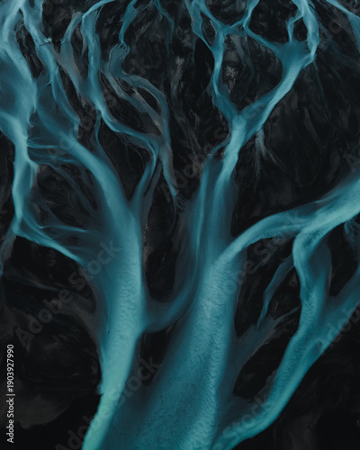 Aerial view of glacial rivers weaving through the stark landscape, a symphony of turquoise veins against the dark earth, Rangarthing eystra, Iceland.