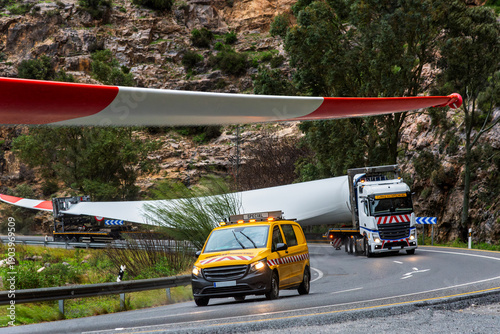 Special transport of an oversized wind turbine blade with pilot escort vehicle on a rural road