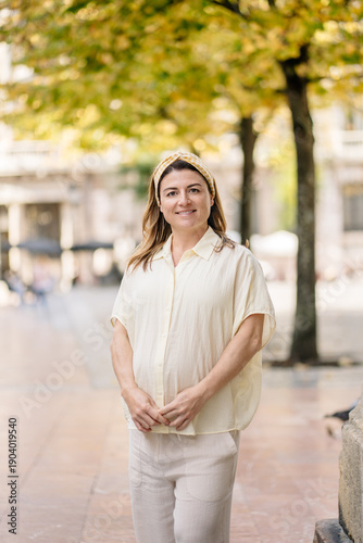 Pregnant woman smiling standing on city street