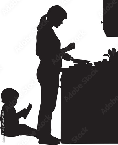 Silhouette of a mother preparing food in kitchen while her little child sits on floor reading a book