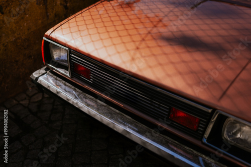 Vintage car with a bronze exterior reflecting sunlight