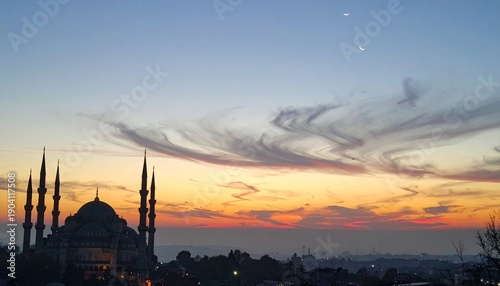 Majestic mosque silhouetted against a sunset sky with crescent moons