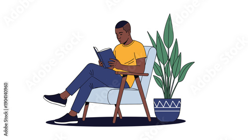 Man sits comfortably in a light blue armchair while reading a blue book in a quiet room with a large potted plant.