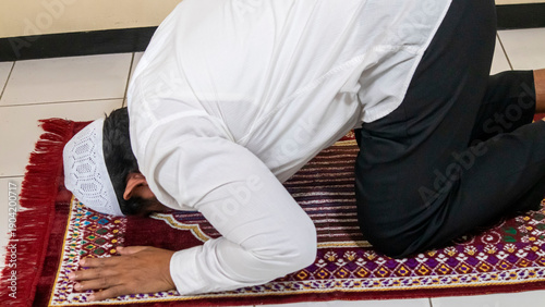 Billede på lærred a Muslim man is praying while prostrating on a prayer mat