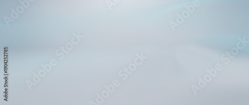 Soft pastel blue abstract gradient background with smooth bokeh light effects for design