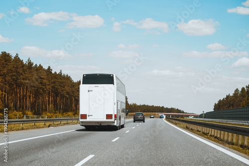 Tableau sur toile White passenger bus driving through countryside