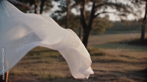 White Fabric Flowing in the Wind Against Sunset Nature Background
