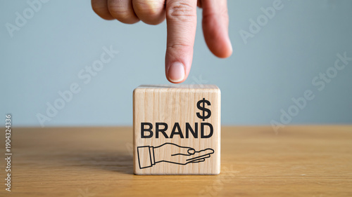 Hand choosing wooden block with brand and money symbol for business branding