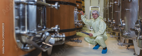 Tableau sur toile Winemaker working in modern large winery factory liquor drink industry quality
