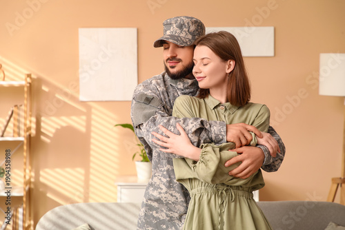Young soldier hugging his w...