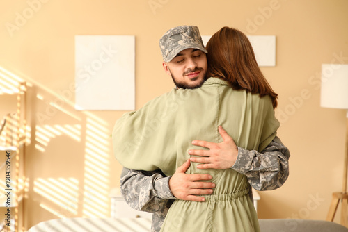 Young soldier hugging his w...