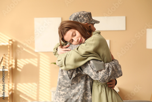 Young soldier hugging his w...