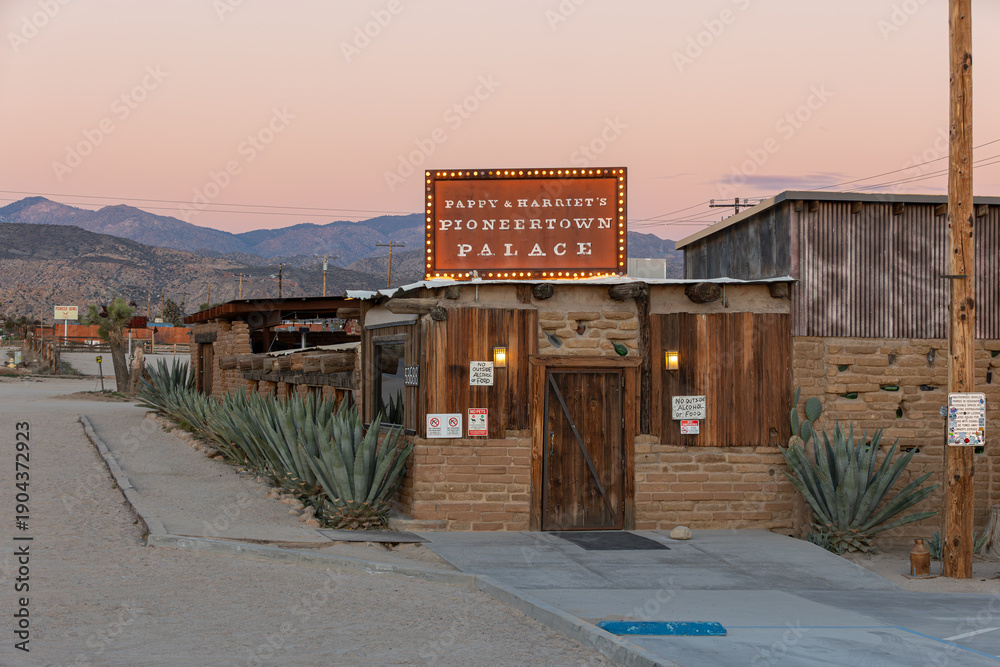Obraz premium PIONEERTOWN, CALIFORNIA, UNITED STATES - Feb 7, 2026: Sign and building of the historic Pappy and Harriet's Pioneertown Palace