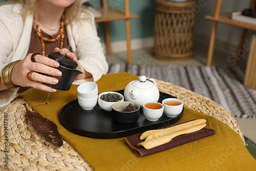Woman with Asian tea set on...
