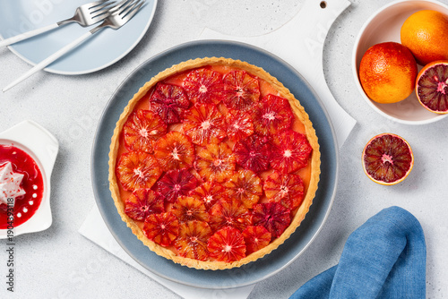 Blood orange tart on a blue plate. Seasonal citrus dessert. Top view