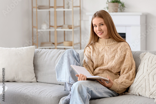 Young woman reading book on...