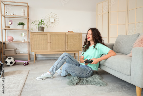 Teenage girl playing video ...