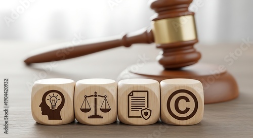 Wooden blocks with symbols of intellectual property rights next to a judge's gavel representing legal concepts
