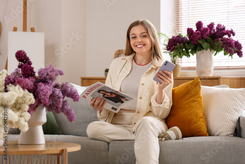 Young woman sitting on sofa...