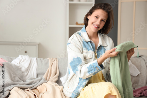 Young happy woman folding c...