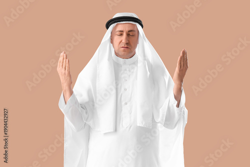 Muslim man praying on beige...