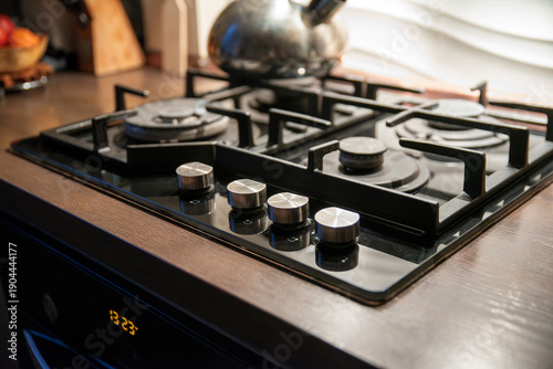 Modern black gas cooktop with knobs