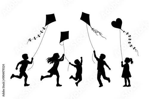 Silhouettes of children flying kites on a clear day.