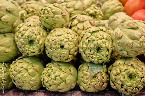 Foto Fresh artichokes stacked closely together emphasize a classic Mediterranean vegetable prized for its earthy flavor and frequent role in traditional home recipes