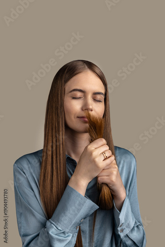 Beauty expert testing new serum on her hair. Beauty Editor Delicately Holding Ponytail Near Face
