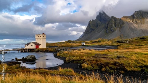 Wallpaper Mural Coastal landscape features a white tower, mountains, water, bridge, grass and a cloudy sky Torontodigital.ca
