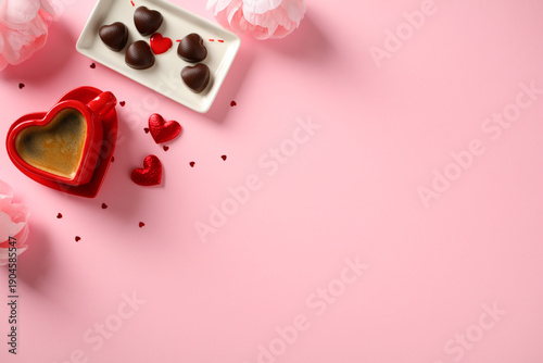 Romantic flat lay with coffee, chocolates, and flowers on a pink background. Happy Valentine's Day concept.