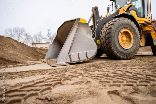 Фотография Front loader digging sand at construction site