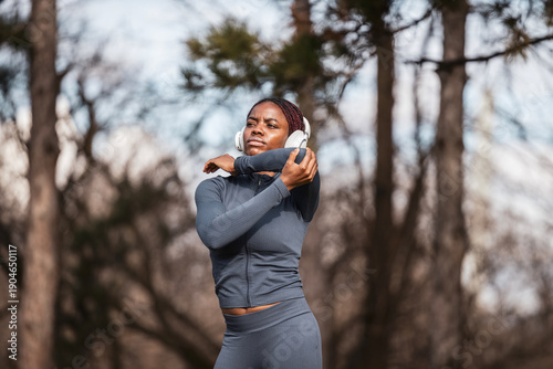 Tableau sur toile African american woman stretching arm outdoors before workout