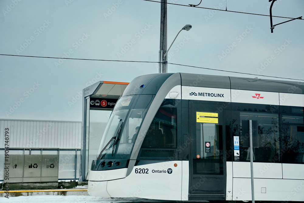 Fototapeta premium Toronto, Ontario, Canada, February 6, 2026: A Metrolinx Eglinton Crosstown LRT test train makes its way along the transit line in Scarborough. This LRT line, after waiting for years to open, is now sc