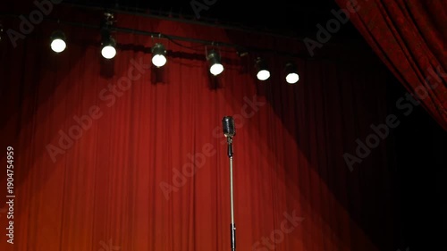Vintage Microphone Lit by Stage Lights with Red Curtain Background