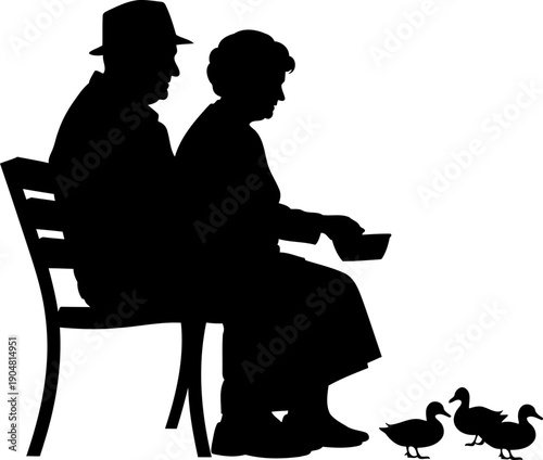 Elderly couple sitting on a bench feeding ducks silhouette