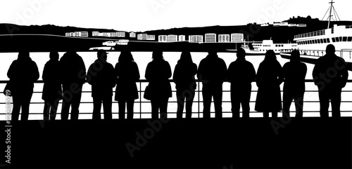 Sightseers leaning on railing watching ferry in harbor