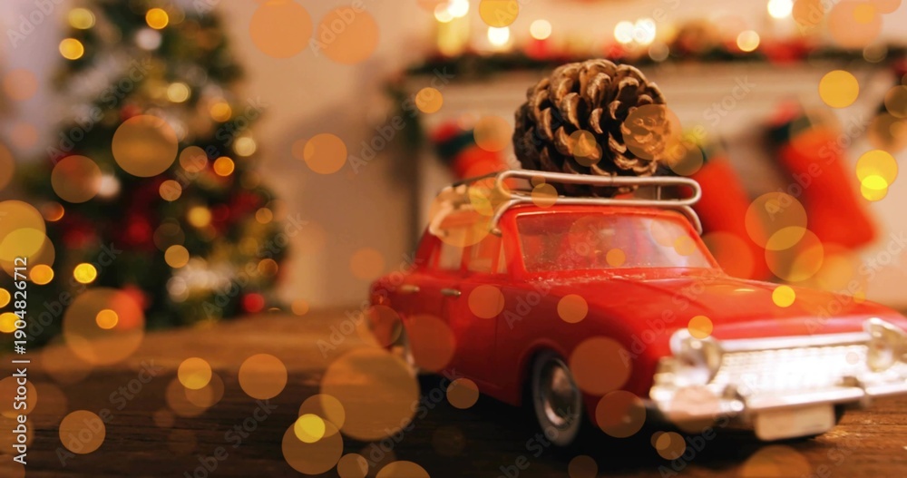 Naklejka premium Displaying red vintage toy car sitting on wooden tabletop in living room, with pinecone roof rack