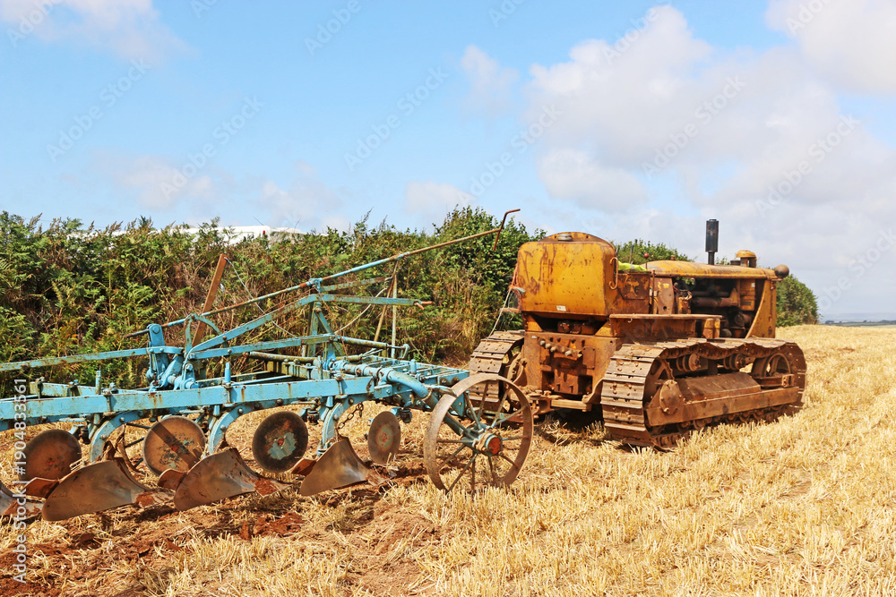 Fototapeta premium Vintage tractor ploughing a field