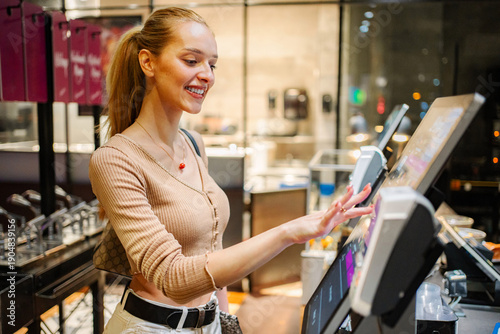 Canvas Print Woman ordering food at self-service kiosk in Vienna