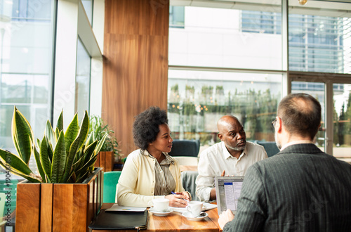 Mature couple meeting with financial advisor in modern cafe