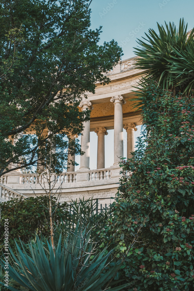 Fototapeta premium Majestic neoclassical architecture surrounded by lush greenery at sunset